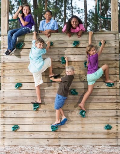 Kinder klettern an einer Indoor Kletterwand hoch