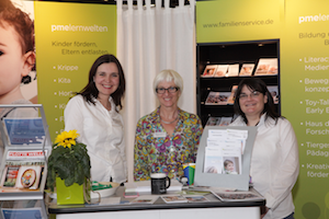 Three women at an exhibition stand.