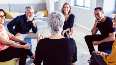 
		Eine Gruppe von Menschen diskutiert im Sitzkreis
	