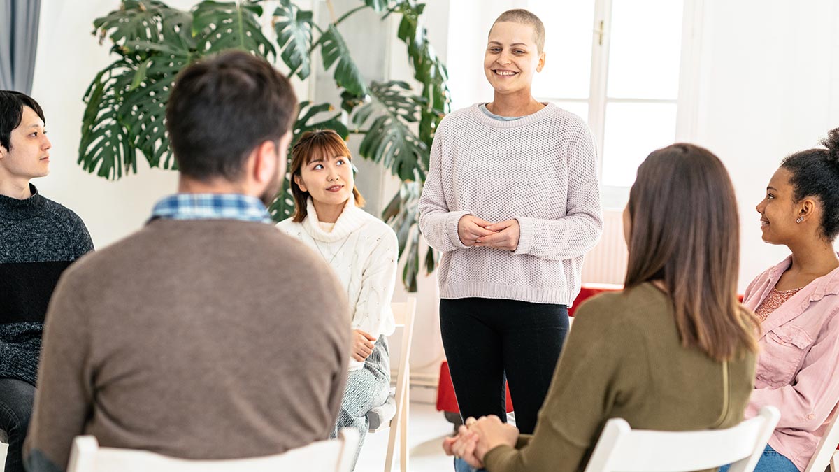 Referentin steht vor einer Gruppe von Seminarteilnehmer:innen