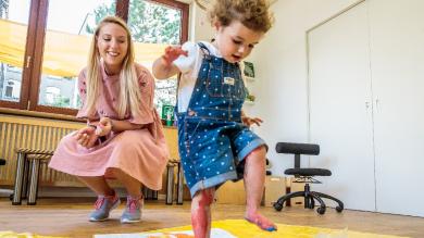 
		Junge Frau schaut kleinem Mädchen zu
	