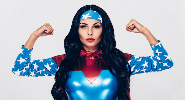 eine Frau im Superwoman-Kostüm und Power-Pose