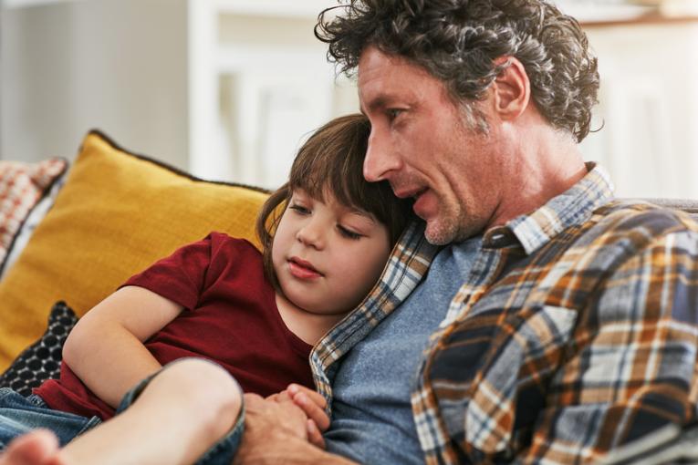Kleines Kind mit Vater auf dem Sofa