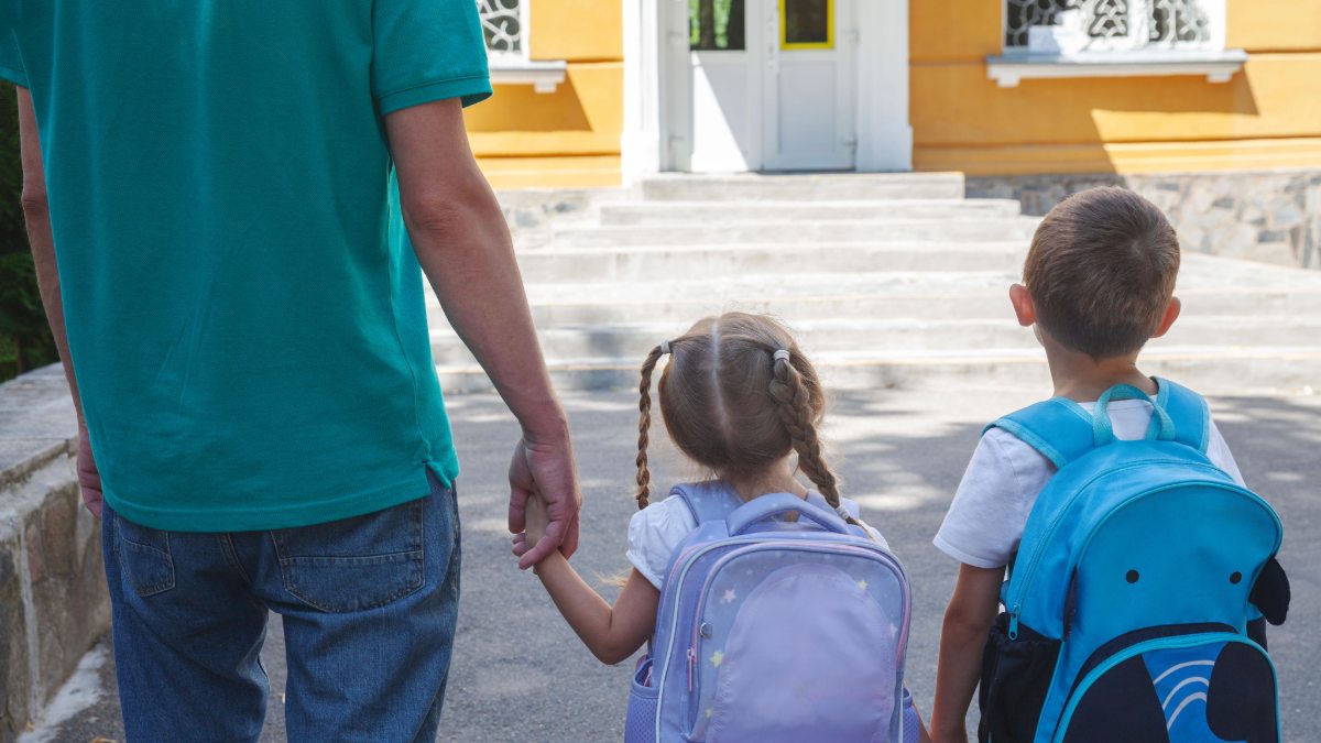 Vater bringt seine Kinder in den Kindergarten