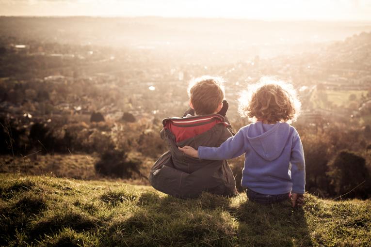 Zwei Kinder blicken über Landschaft