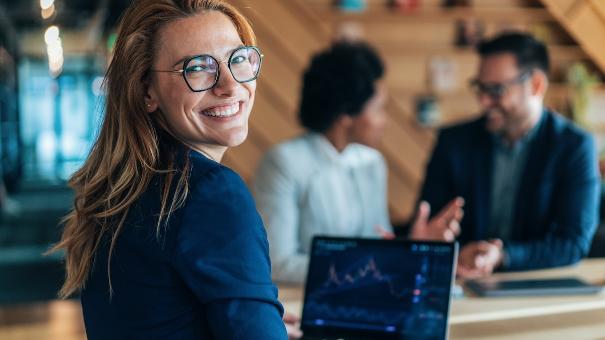 
		Frau rechnet am Schreibtisch mit Laptop im Büro etwas aus
	
