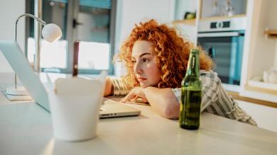 
		Frau sitzt vor Bildschirm-Meeting
	