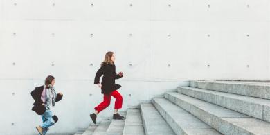 
		Zwei Frauen rennen die Treppe hintereinander hoch
	