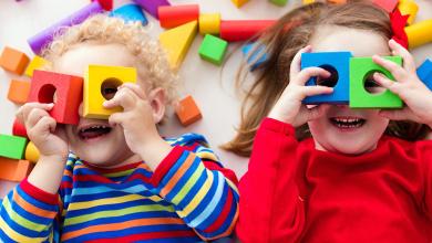 
		zwei Kinder schauen durch bunte Bausteine durch
	