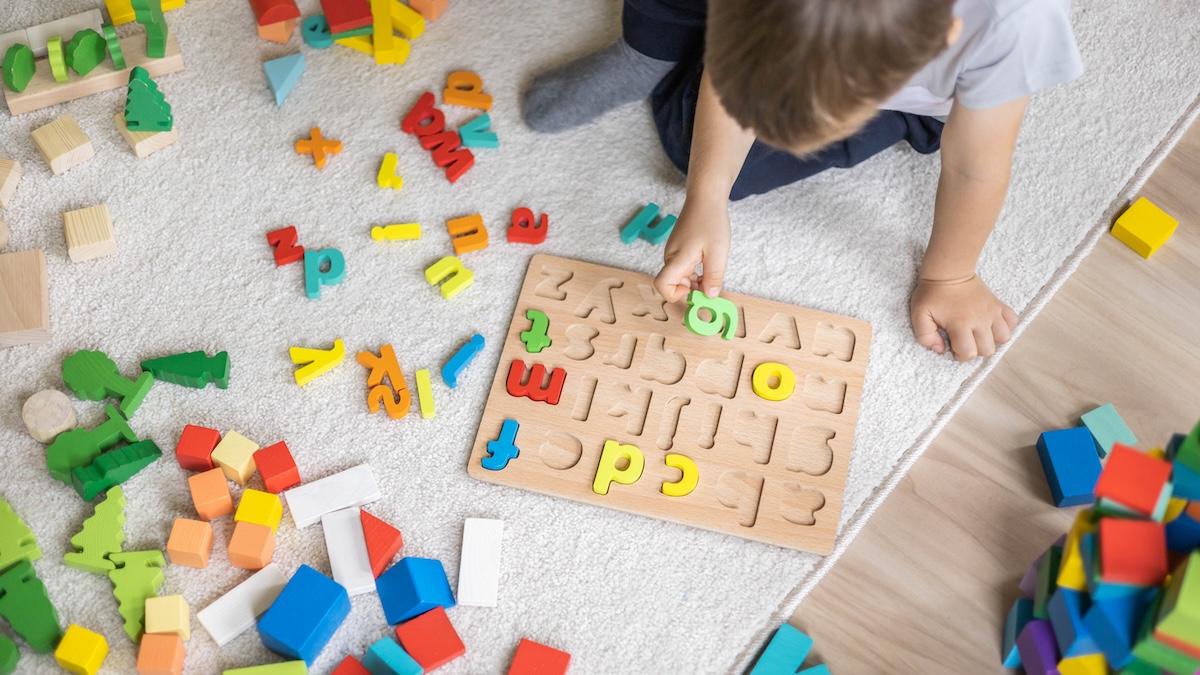 Kind spielt mit bunten Buchstaben