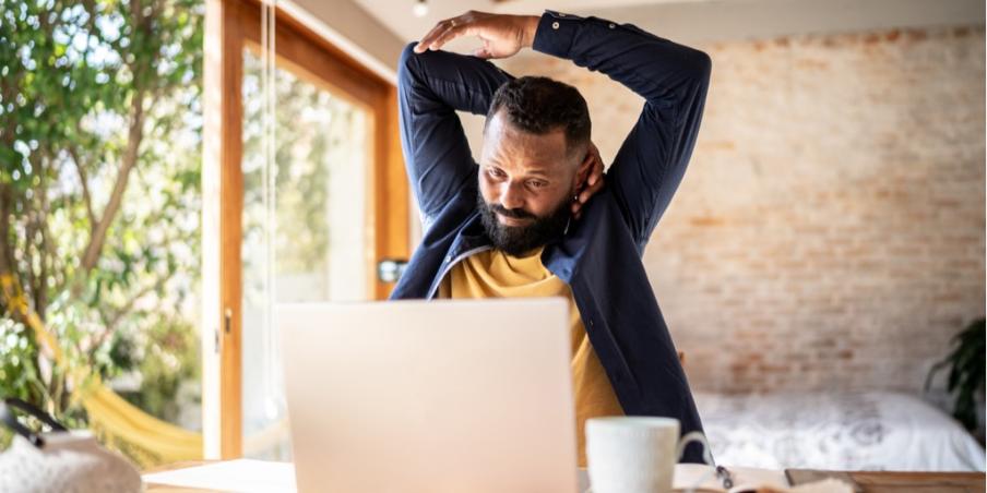 Mann am Schreibtisch stretcht Nacken